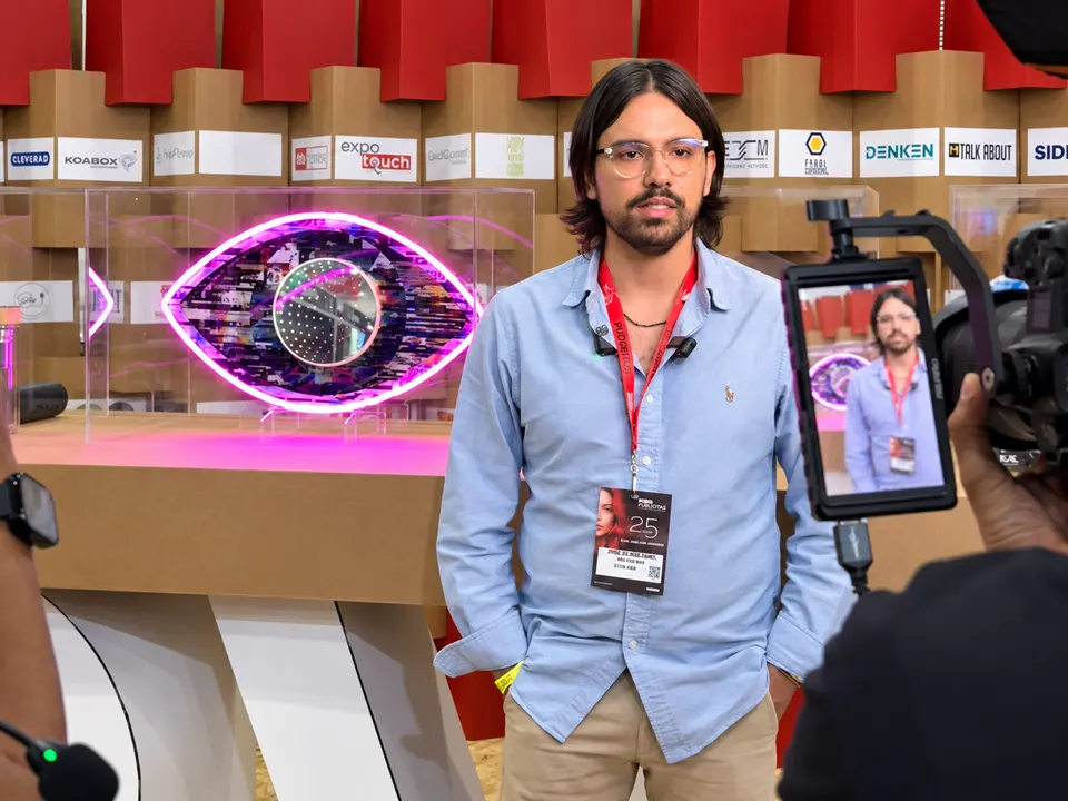 Alfonso Rao entrevistado en Expo Publicitas 2026 junto a un letrero de Electric Neon